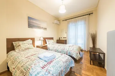 a bedroom with two beds and a window at Stylish Athens Apt 10 Minute Walk to Acropolis Museum & Metro in Athens