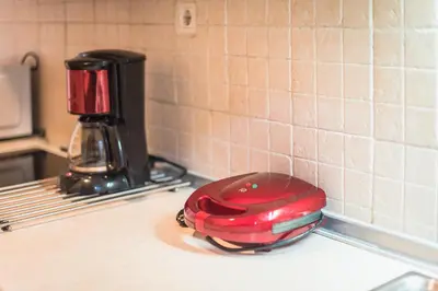 a red appliance sitting on top of a kitchen counter at Stylish Athens Apt 10 Minute Walk to Acropolis Museum & Metro in Athens