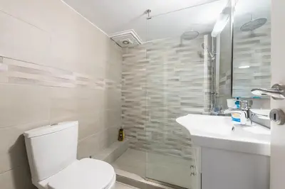 a white bathroom with a toilet and a sink at Stylish Athens Apt 10 Minute Walk to Acropolis Museum & Metro in Athens