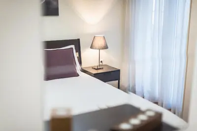 a bedroom with a bed and a table with a lamp at Stylish Athens Apt 10 Minute Walk to Acropolis Museum & Metro in Athens