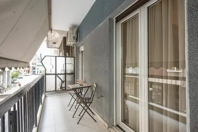 a balcony with chairs and a table on it at Stylish Athens Apt 10 Minute Walk to Acropolis Museum & Metro in Athens