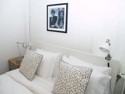 a white bed with white pillows and a picture on the wall at Artistic Deco Apartment in Athens