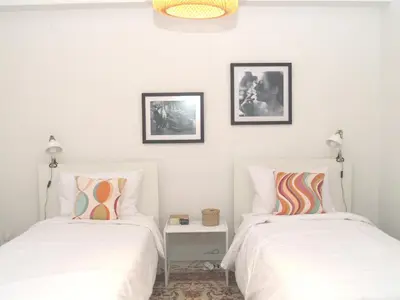 two beds in a room with white walls at Artistic Deco Apartment in Athens