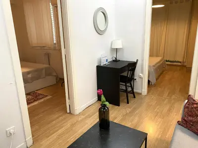 a room with a desk and a table with a vase at Artistic Deco Apartment in Athens