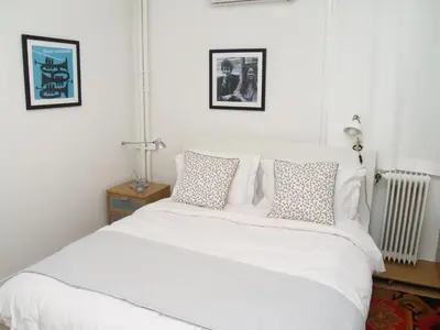 a bedroom with a white bed with pillows and a radiator at Artistic Deco Apartment in Athens