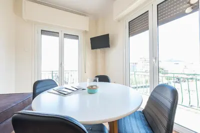 a white table and chairs in a room with windows at Super Paradise Apartments in Athens