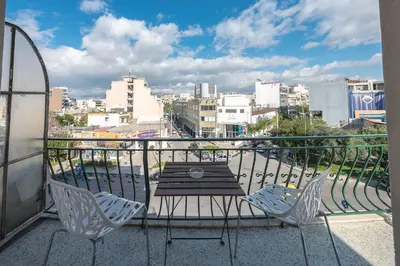 a table and chairs on a balcony with a view of a city at Super Paradise Apartments in Athens