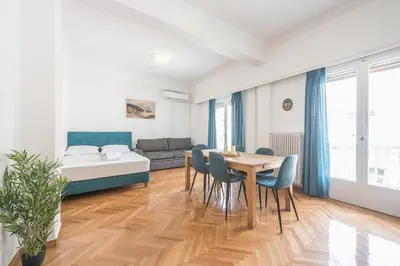 a living room with a table and chairs and a bed at Victoria Sun Apartments in Athens