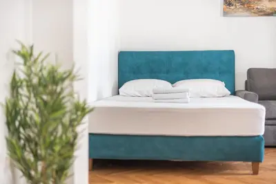 a bed in a room with a blue headboard at Victoria Sun Apartments in Athens