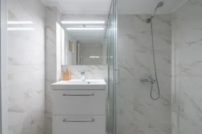 a white bathroom with a sink and a shower at Victoria Sun Apartments in Athens