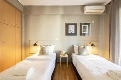 two beds in a room with white walls at Renovated 3 bedroom apt with Acropolis View in Athens