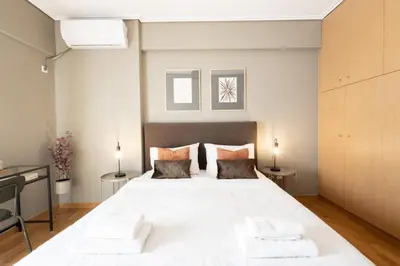 a bedroom with a large white bed with two pillows at Renovated 3 bedroom apt with Acropolis View in Athens