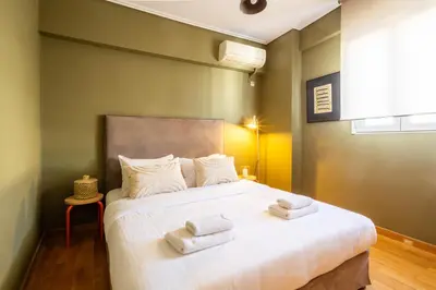 a bedroom with a large bed with towels on it at Renovated 3 bedroom apt with Acropolis View in Athens