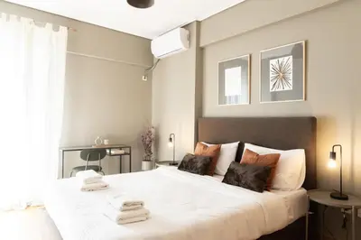 a bedroom with a large white bed with towels on it at Renovated 3 bedroom apt with Acropolis View in Athens