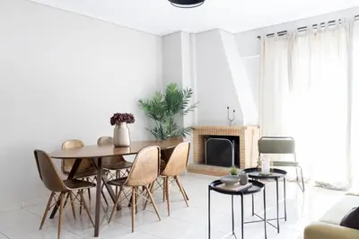 a living room with a table and chairs and a fireplace at Renovated 3 bedroom apt with Acropolis View in Athens