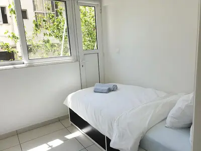a white room with a bed and two windows at KYMA Apartments - Athens Acropolis 13 in Athens