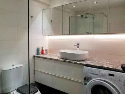 a bathroom with a sink and a washing machine at KYMA Apartments - Athens Acropolis 13 in Athens