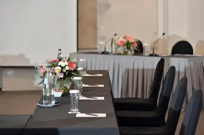 a table with flowers on top of it with chairs at Athenaeum Grand Hotel in Athens