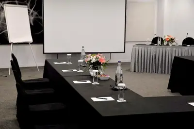 a long black table with glasses and flowers on it at Athenaeum Grand Hotel in Athens
