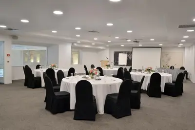 a conference room with white tables and black chairs at Athenaeum Grand Hotel in Athens