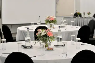 a group of tables with bottles and flowers on them at Athenaeum Grand Hotel in Athens