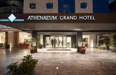 a lobby of a grand hotel with people walking in it at Athenaeum Grand Hotel in Athens