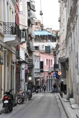 an empty street with motorcycles parked on the sides of buildings at Ulysses Apartments Monastiraki in Athens