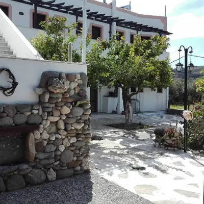 a stone wall in front of a building at Παραθαλασσια στουντιο Μιχαλιας Sea view studio Michalias in Agia Marina Aegina