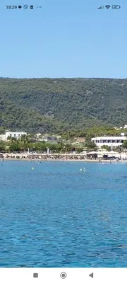 a large body of water with a beach in the background at Παραθαλασσια στουντιο Μιχαλιας Sea view studio Michalias in Agia Marina Aegina