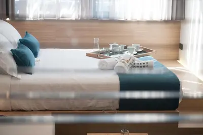 a bedroom with a bed with a table and towels at Athens Lodge by Athens Prime Hotels in Athens