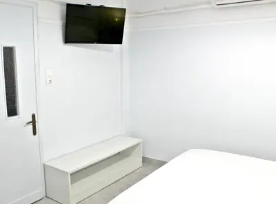 a white room with a tv on the wall at By the Acropolis, In the heart of Plaka! in Athens