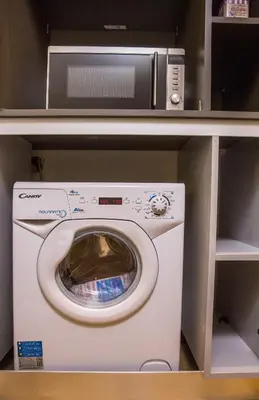 a microwave and a washing machine on a shelf at Skoufa Apartment in Athens