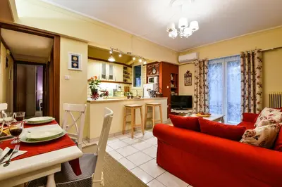 a living room with a red couch and a kitchen at Star Parthenon Apartment in Athens