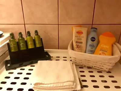 a bathroom counter with bottles of soap and a basket at Star Parthenon Apartment in Athens
