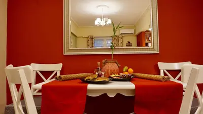 a dining room with a table with a red wall at Star Parthenon Apartment in Athens