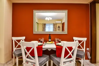 a dining room with a table with chairs and a mirror at Star Parthenon Apartment in Athens