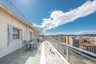 a balcony with a table and chairs on a building at ATHENStay Penthouse Suite in Athens