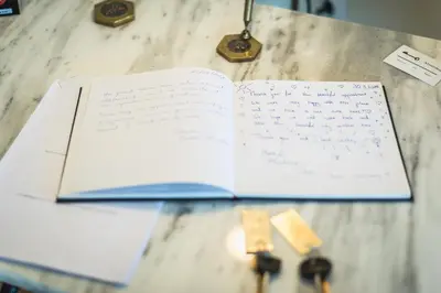 an open book on a table with writing on it at ATHENStay Penthouse Suite in Athens