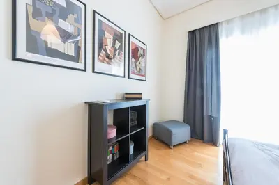 a bedroom with a black cabinet and pictures on the wall at ATHENStay Penthouse Suite in Athens
