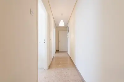 an empty hallway with white walls and a mirror at ATHENStay Penthouse Suite in Athens