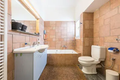 a bathroom with a toilet and a sink and a tub at ATHENStay Penthouse Suite in Athens