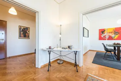 a living room with a table and a chair at ATHENStay Penthouse Suite in Athens