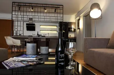 a living room with a couch and a table with a wine glass at Elliniko Luxury Residence by First Class Properties in Athens