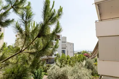a pine tree in front of some buildings at Elliniko Luxury Residence by First Class Properties in Athens
