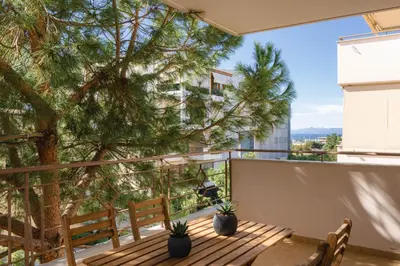 a balcony with a wooden bench and a tree at Elliniko Luxury Residence by First Class Properties in Athens