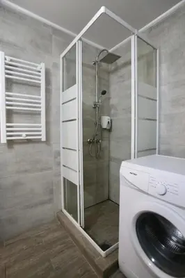 a bathroom with a shower and a washing machine at GK Ermou Str in Athens