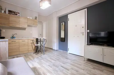 a living room with a television and a kitchen at GK Ermou Str in Athens