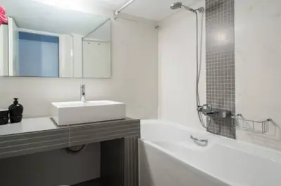 a bathroom with a sink and a mirror and a tub at Glyfada Riviera Home in Athens