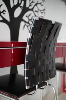 a red and black chair with a tree on the wall at Glyfada Riviera Home in Athens