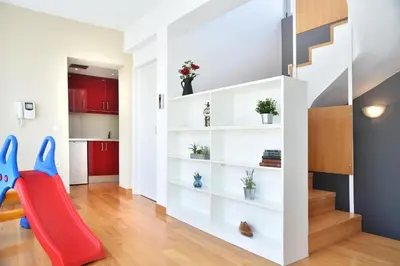 a living room with a red slide and white shelves at Villa Amaryllis in Athens